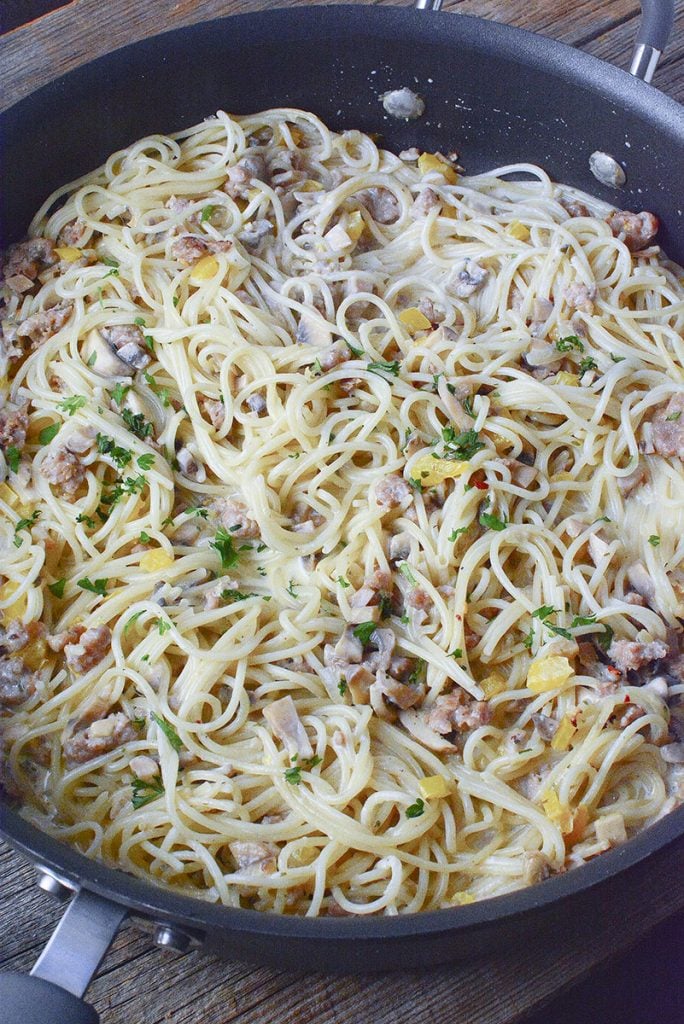 Practically made in one pan, this cheesy pasta dish with sausage, peppers, mushrooms and onions is super delicious!