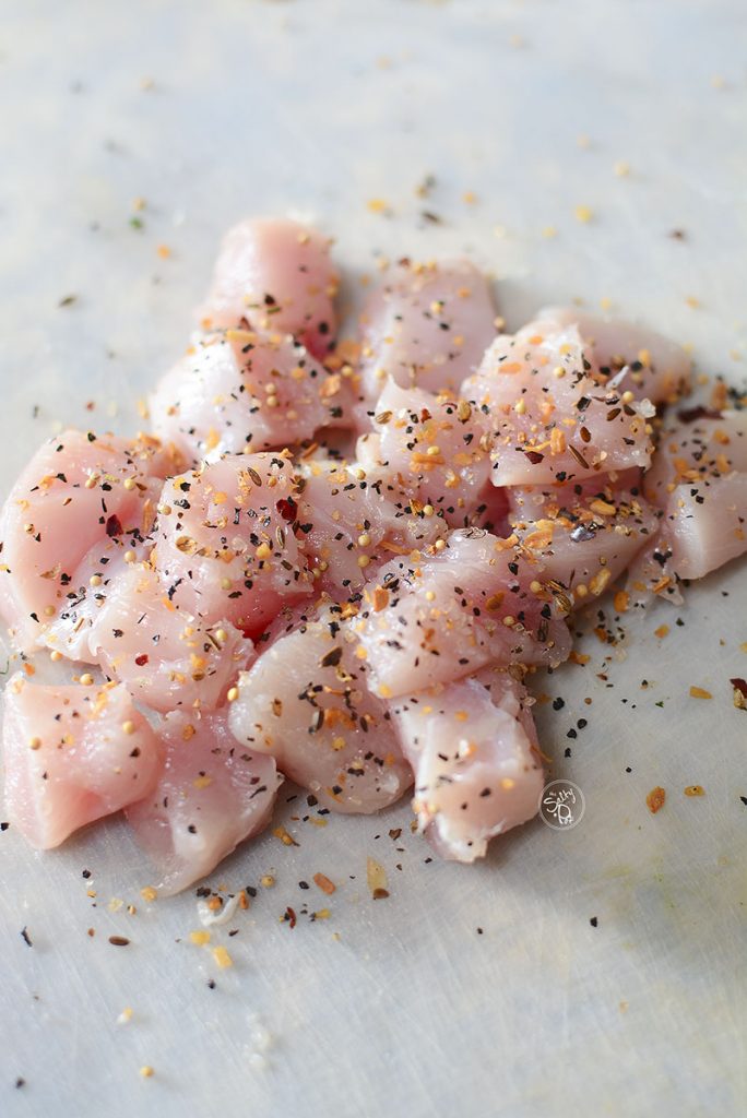 A chicken breast that's been diced into chunks and seasoned with Montreal steak seasoning.
