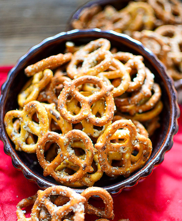 Seasoned pretzels in a dark bowl with a red napkin underneath.