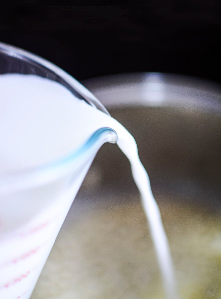 Milk being poured into the pot.