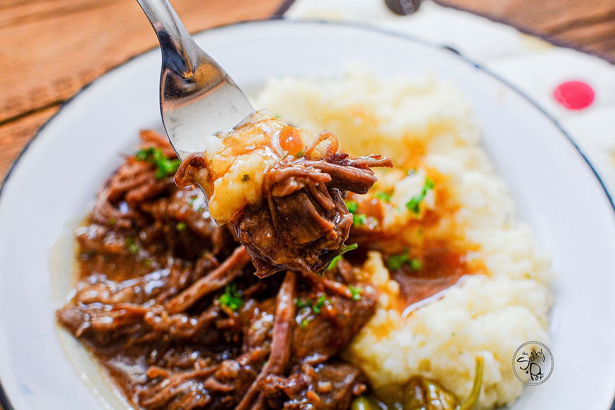 Mississippi Pot Roast with mashed potatoes on a white plate.