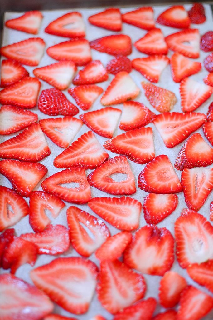 Sliced strawberries on the dryng pan ready to go into the oven to dehydrate.