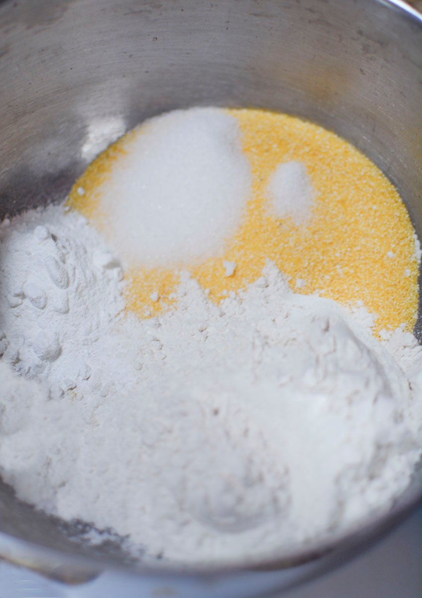 More ingredients for the cornbread mix are added to the bowl. 