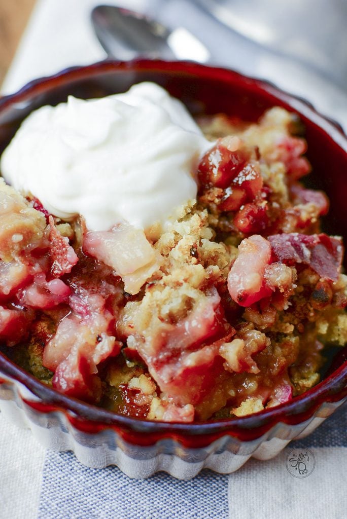 The closest view yet of this dessert is in this photo. Bits of the pear and rhubarb can be seen mixed in with the crumble topping. Whipped cream is dolloped over the top. 