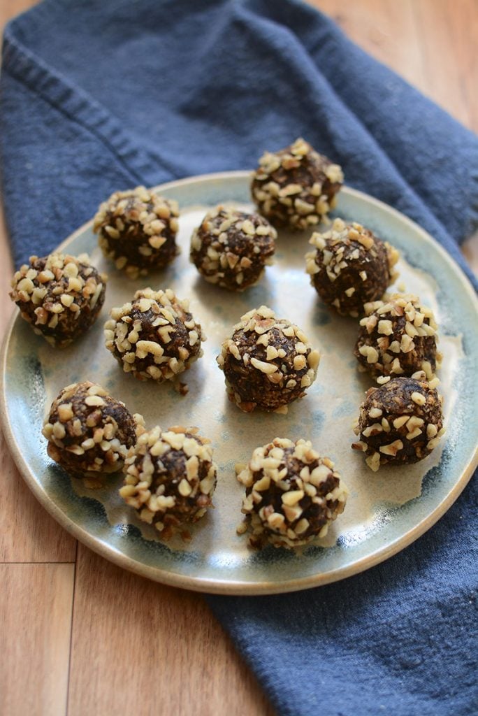 An overhead image of the walnut date balls on a pottery plate.