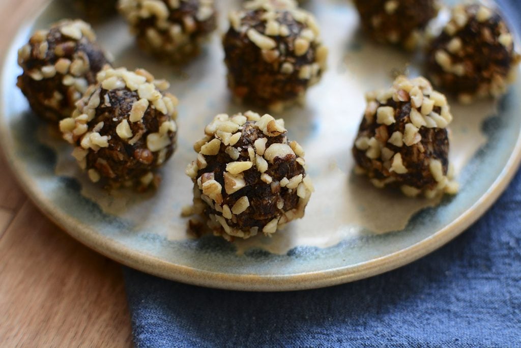 A close up side image of the date walnut balls on a blue and grey plate.