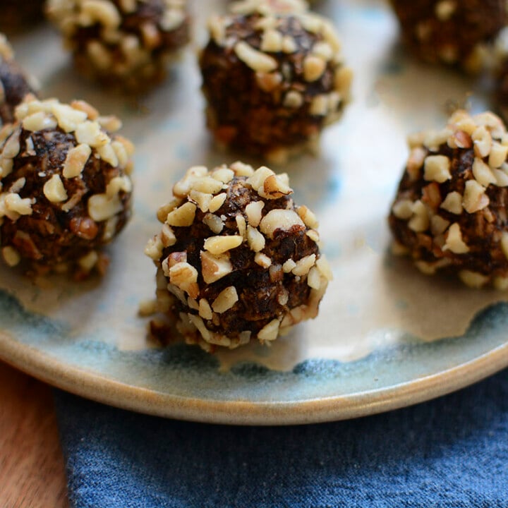 A close up side image of the date walnut balls on a blue and grey plate.