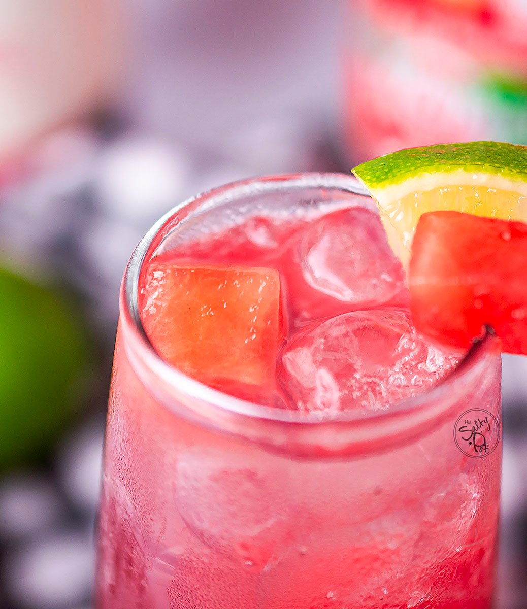 A close up photo of the drink that shows the top of the glass with the fruit on the rim.