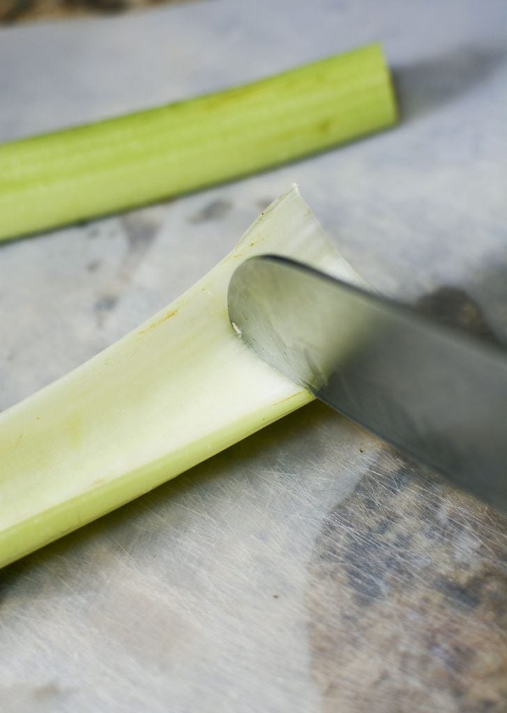Carefully cutting through the celery stalk but not going all the way to the bottom.