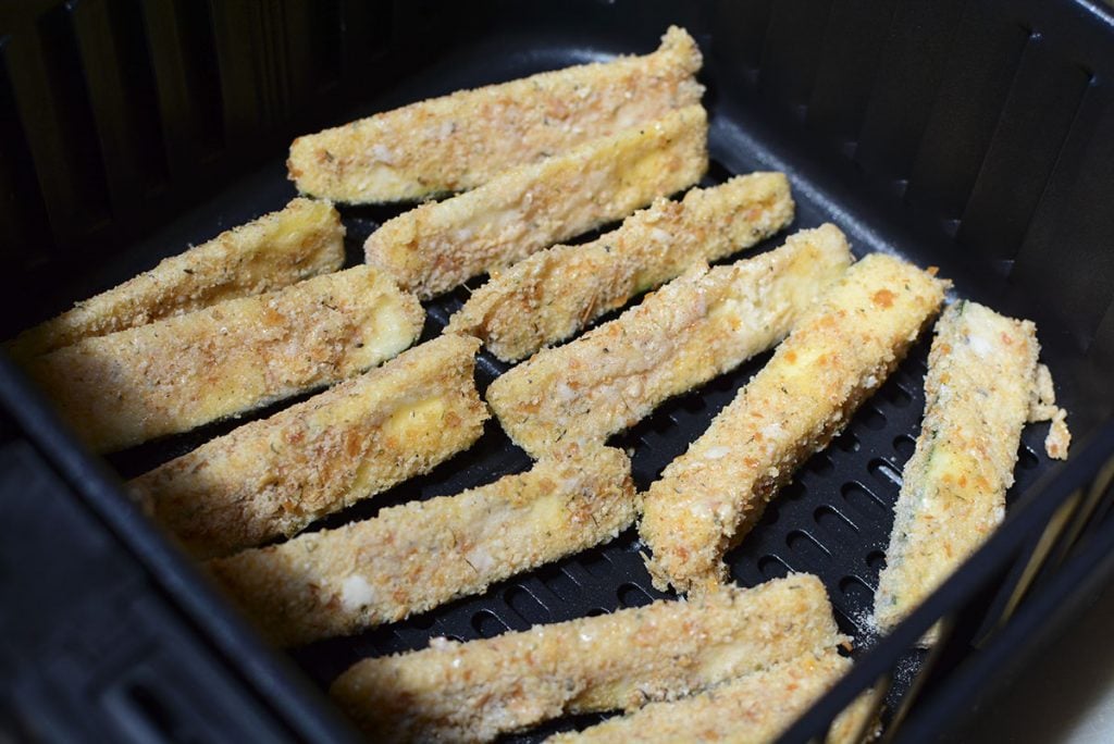 Zucchini fries in the fryer before the cheese has been put on.