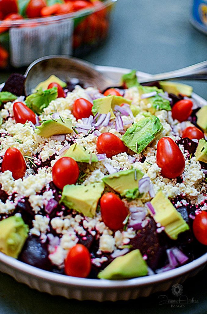 Avocado Beet and Feta salad with a spoon in the dish, in the background.