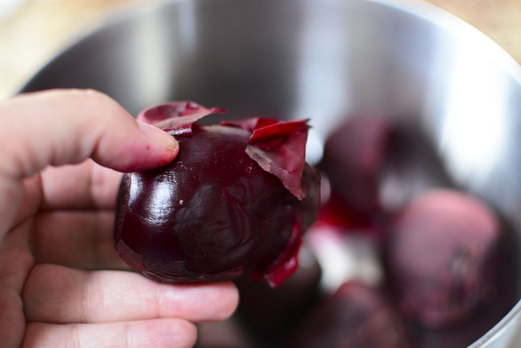 A beet with some of the peel coming off.