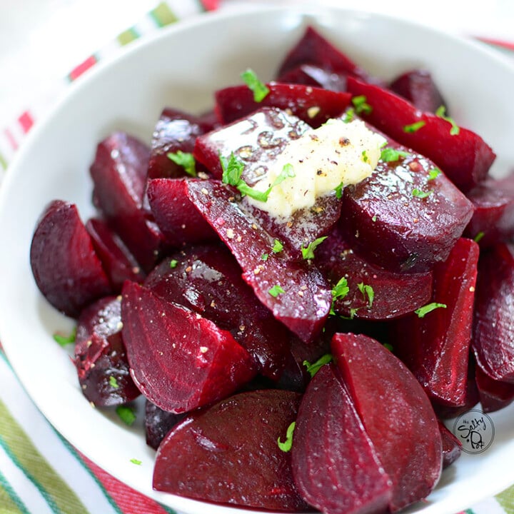 Beets in a white bowl with butter on top.