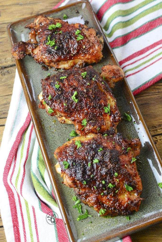 The chicken thighs sitting on a long green serving platter.