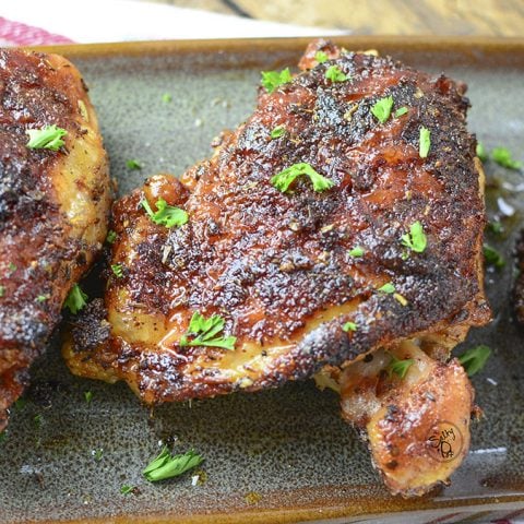 Air fried chicken thighs sitting on a plate.