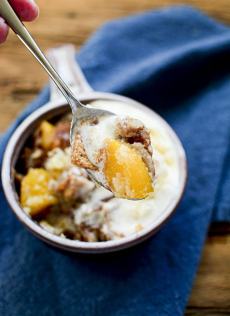 A spoonful of the peach cobbler served with ice cream. 
