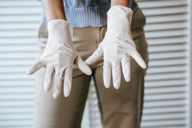 A person showing their hands gloved.