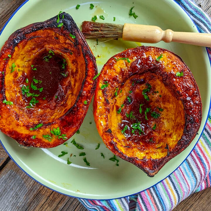 A horizontal overhead photo of two halves of an acorn squash that's been air fried.