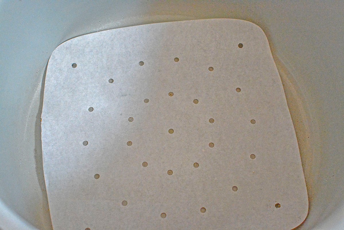 The parchment paper liner at the bottom of the air fryer basket.