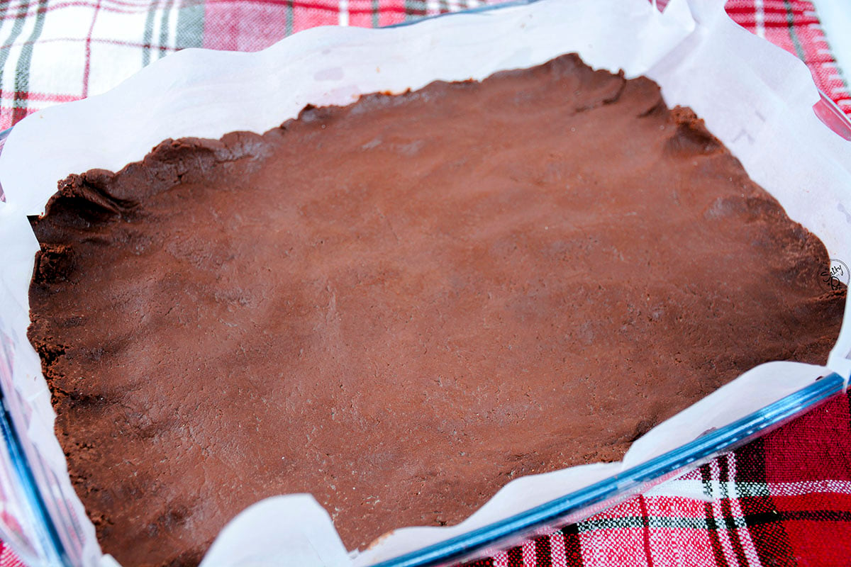 The first layer of the chocolate peppermint fudge is in the pan that's lined with parchment paper. 