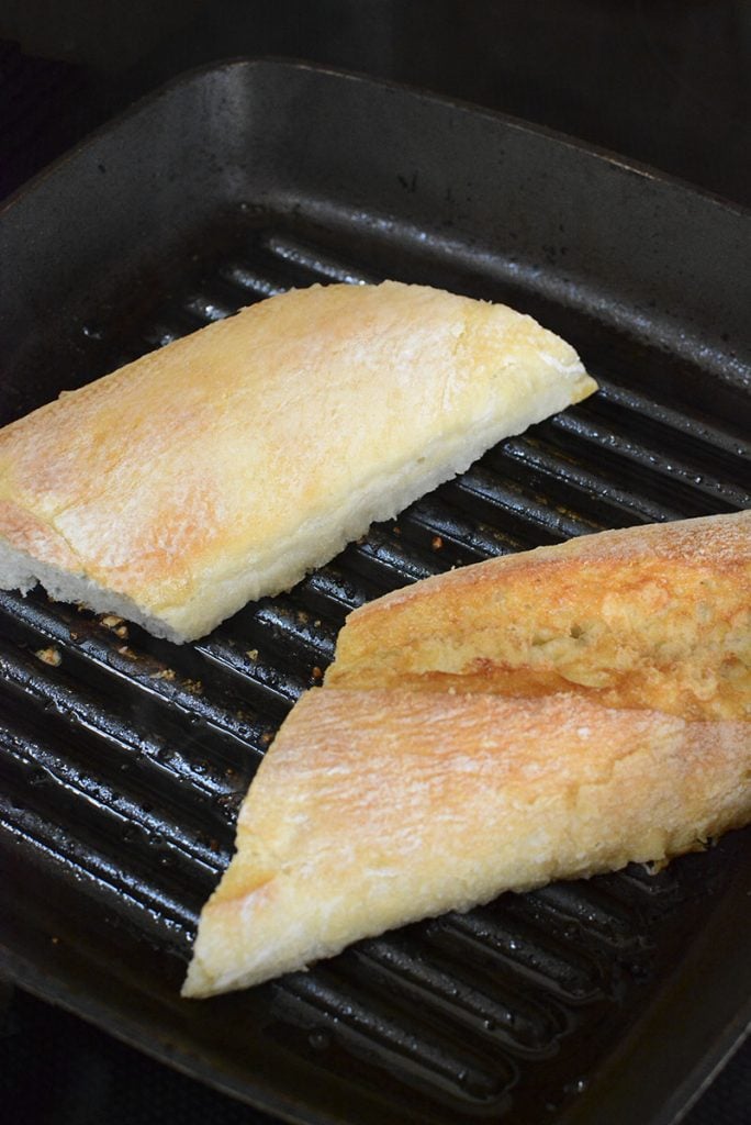 Sliced horizontally, the baguette is toasted on the grill pan while the steaks are resting.