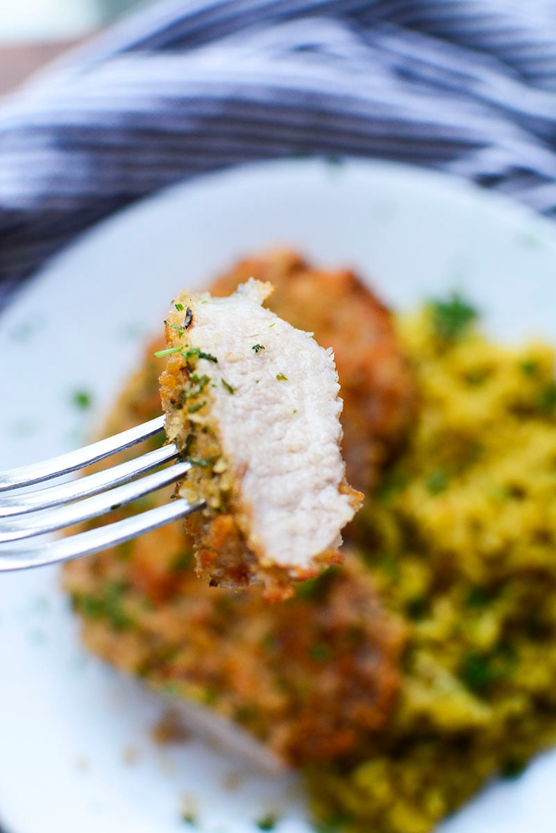 A bite of pork steak on a fork.