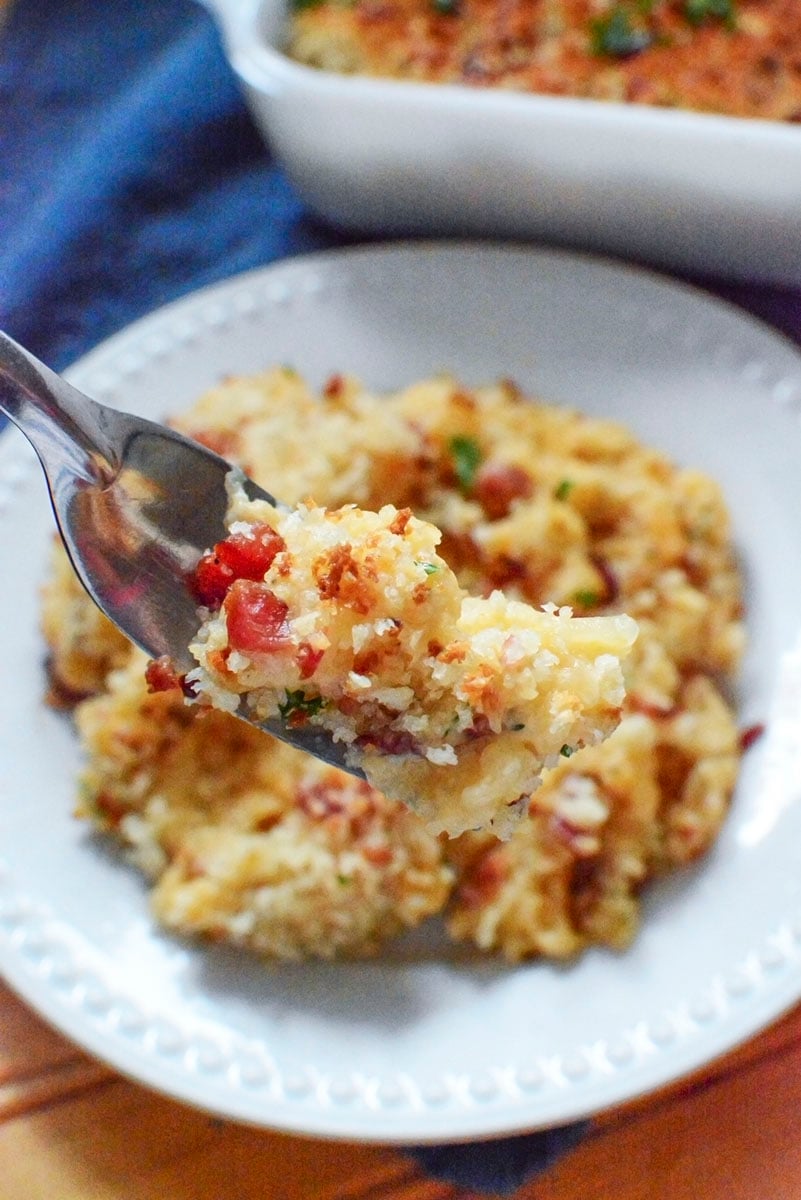 A forkfull of the veggie cassole with a white plate in the background.