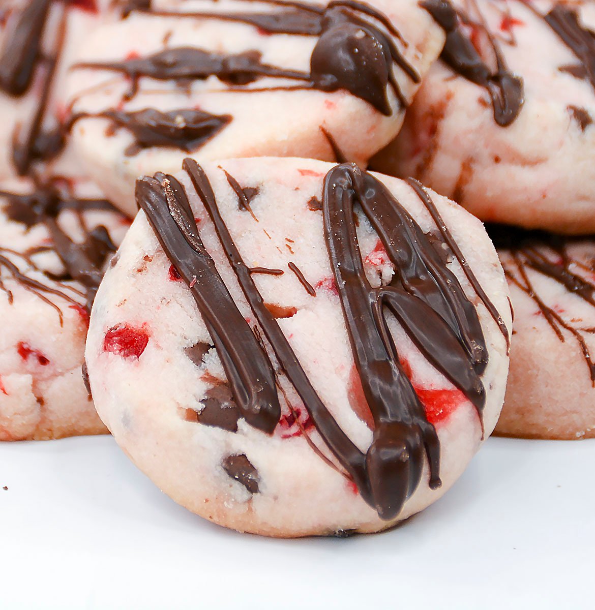 A close up of a maraschino cherry shortbread cookie.