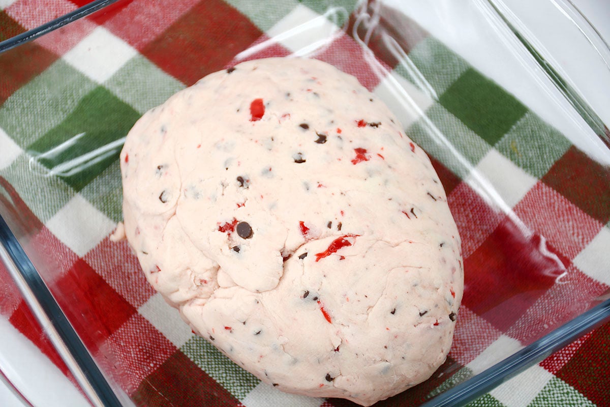 The cherry chocolate cookie dough in a dish sitting on top of a red and green napkin.