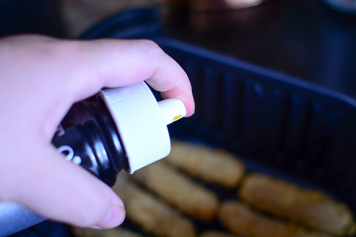 Spraying the fries with avocado oil before cooking.