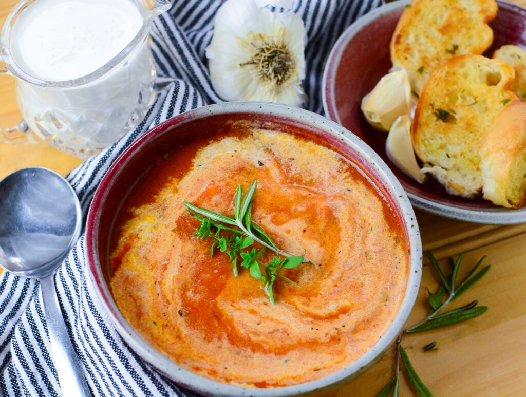 Tomato soup with herbs resting on the top.