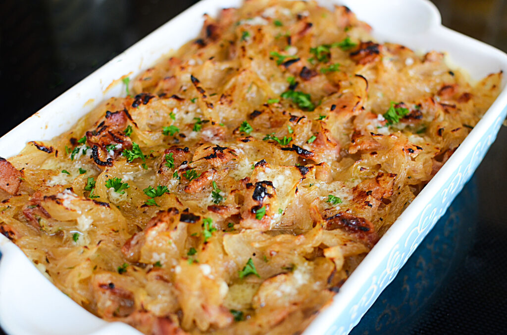 A casserole dish showing the caramelized onions on top of the potatoes.