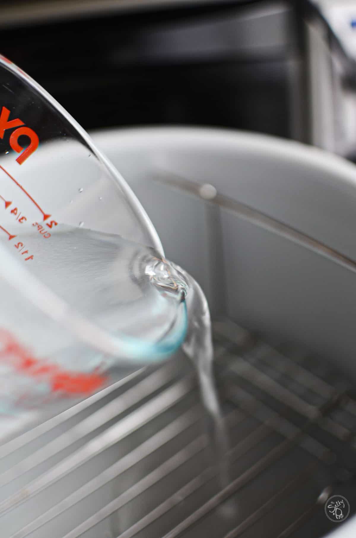 Pouring the water into the foodi bowl.