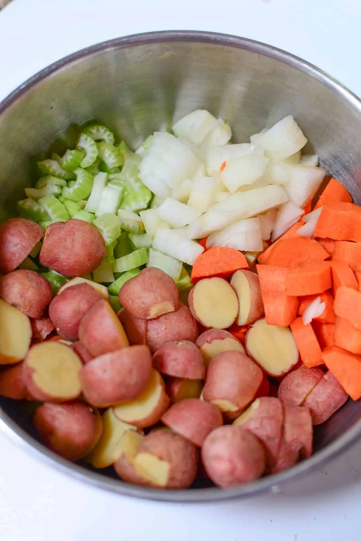 The vegetables going into the stew in a silver bowl. 
