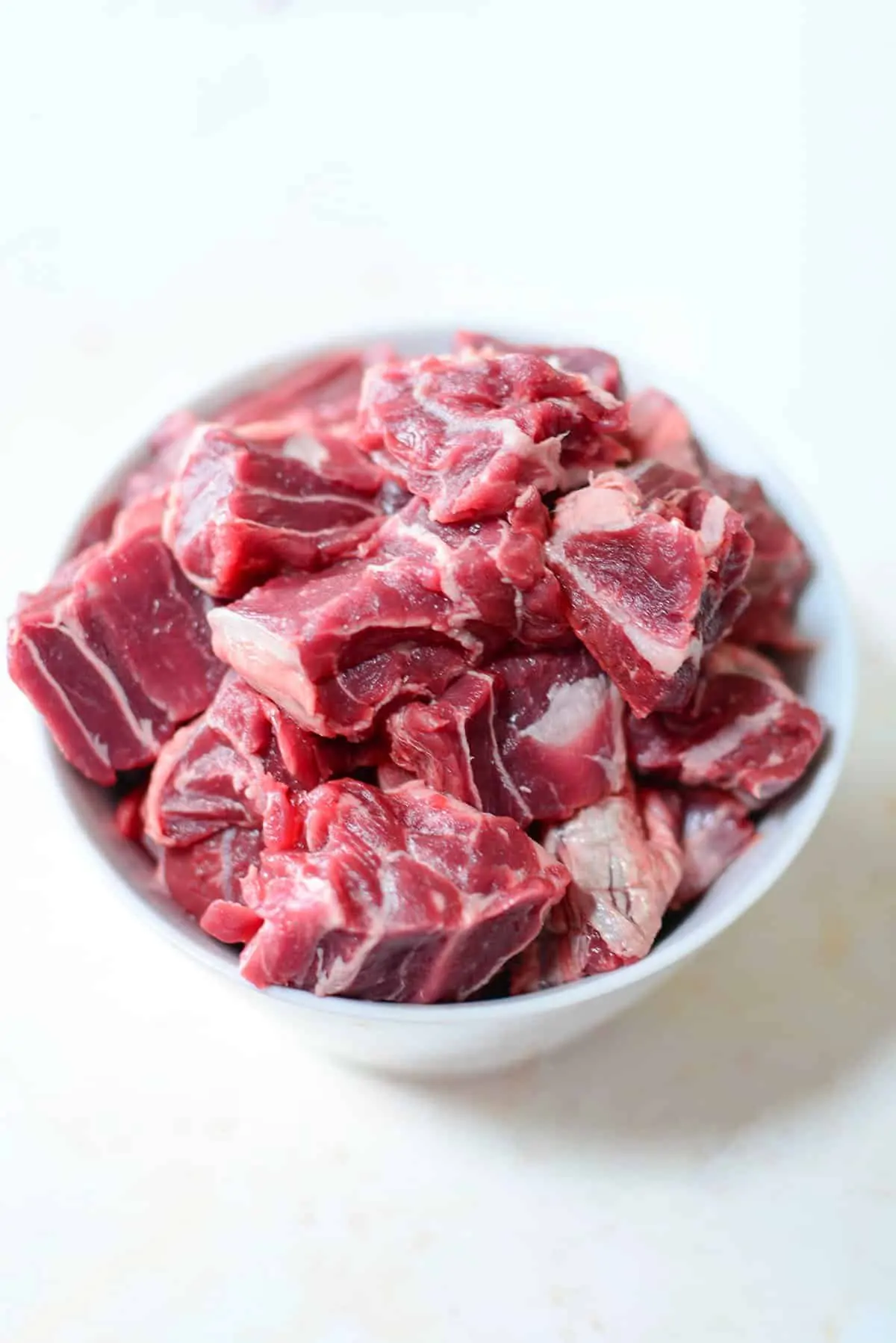 Shank meat cut up and placed in a white bowl. 
