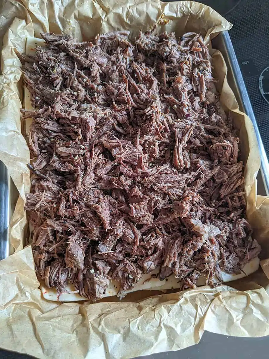 Shredded roast beef placed over top the cheese to make the roast beef sliders.