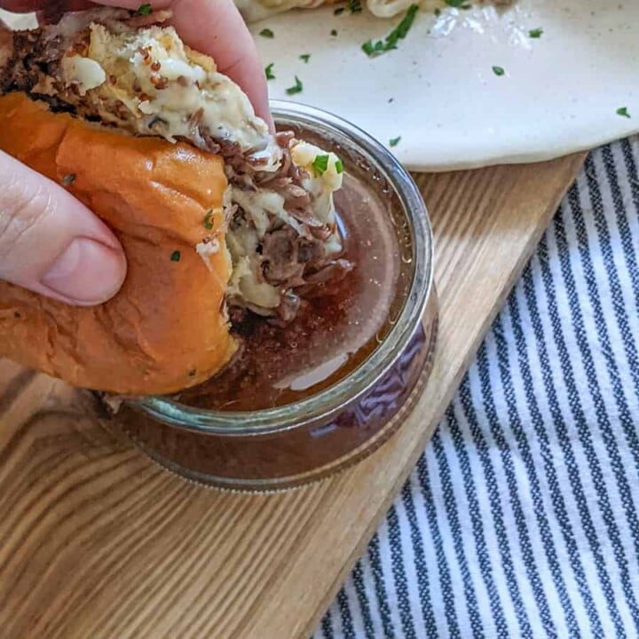 A slider being dipped into the au jus.