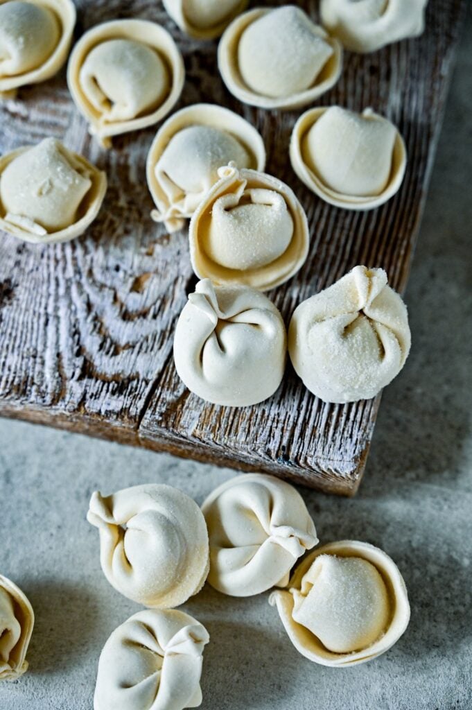 Tortellini freshly made on a wooden board.