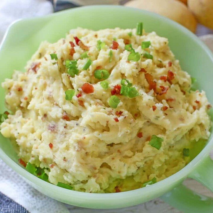 Mashed potatoes with Boursin Cheese in a green bowl.