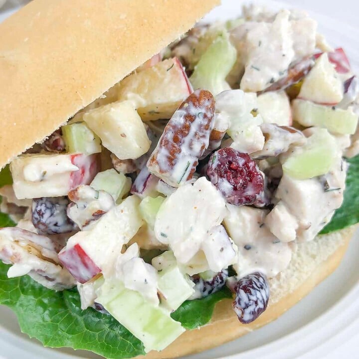 Chicken salad on a bun with lettuce underneath.