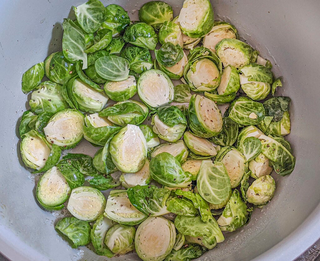 Halved brussels sprouts frying in the pot.