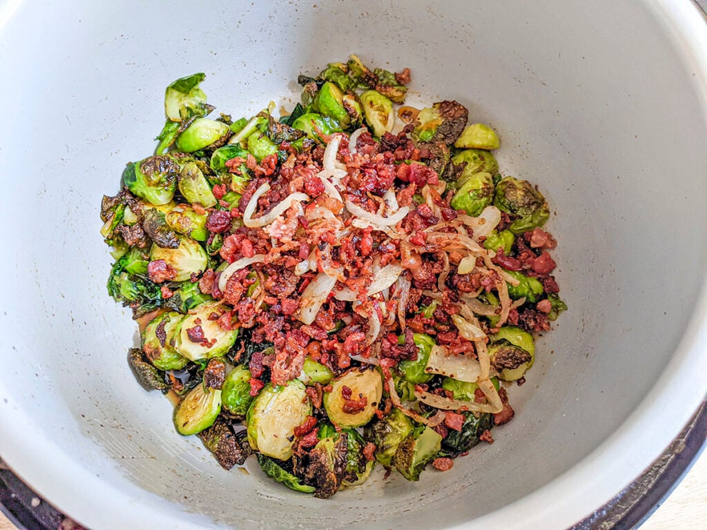The sprouts are fried to get crispy and the bacon and onions are added back. 