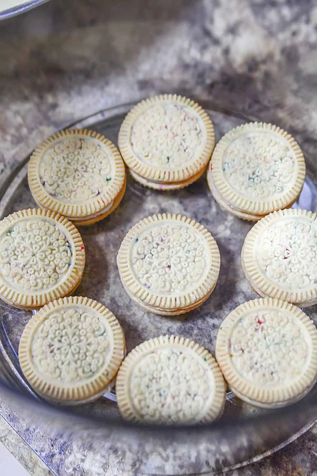 Nine cookies line the bottom of a glass trifle bowl.