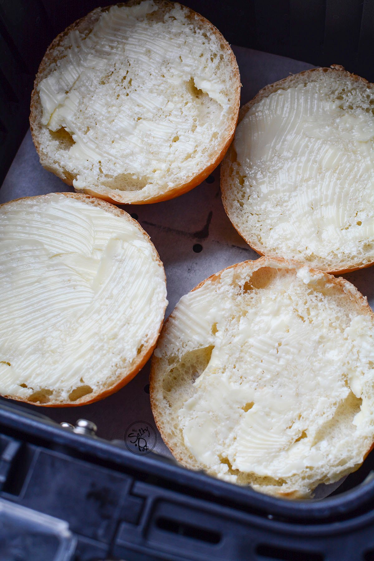 Buttered buns in the air fryer for toasting. 