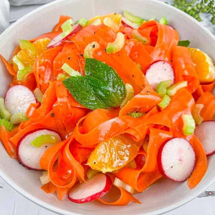 Shaved carrot salad in a white bowl.