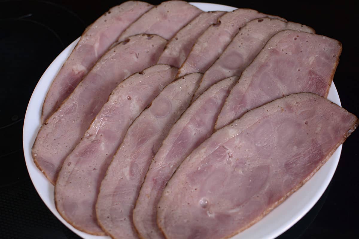 Slices of raw turkey bacon on a white plate.
