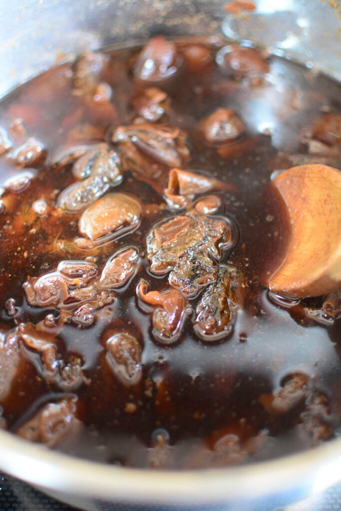 Boiled dates in the pot with a wooden spoon on the right.