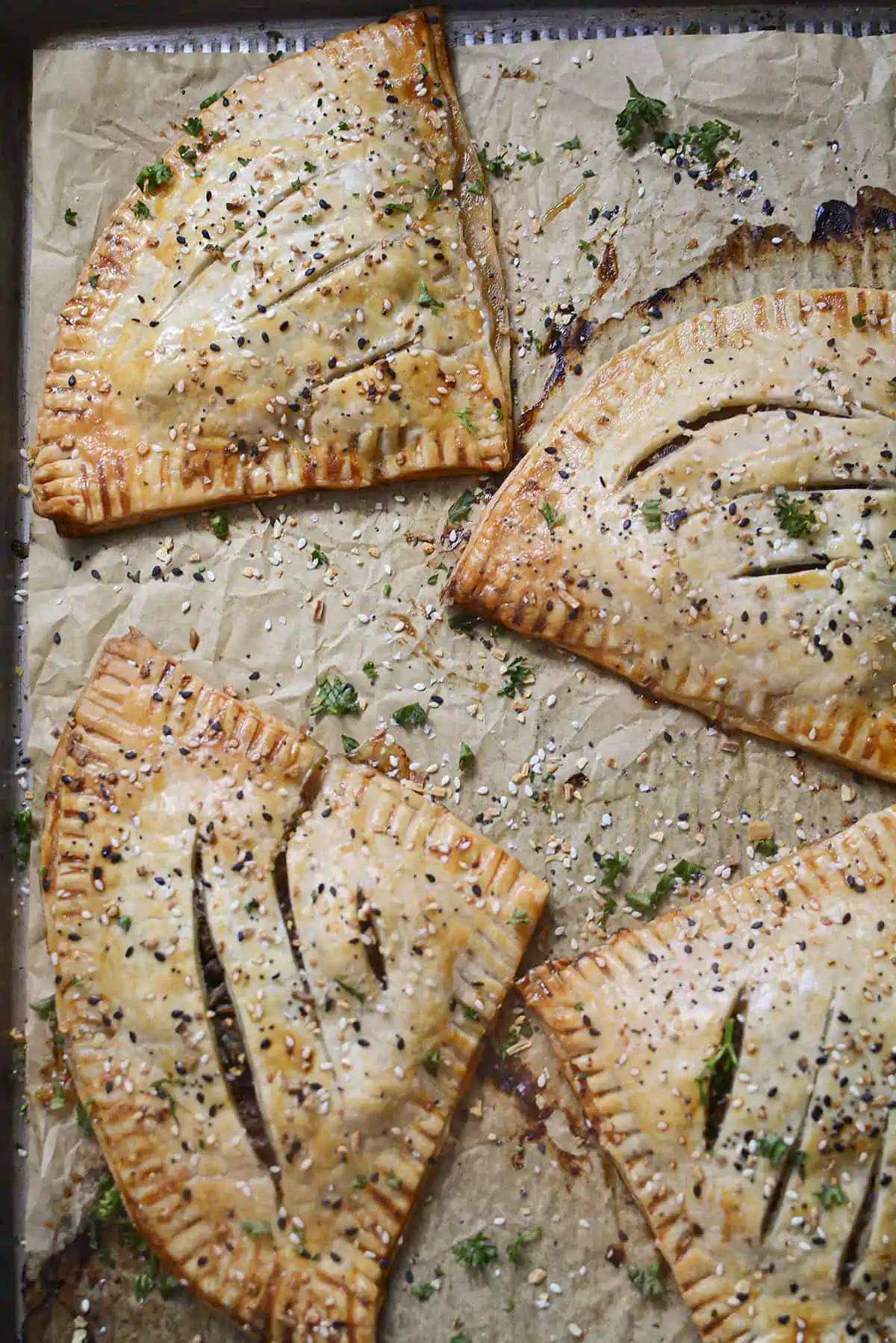 Four beef hot pockets on a parchment lined baking dish.