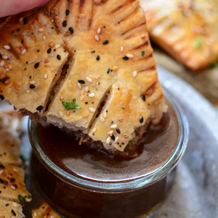 A roast beef pocket about to be dunked in gravy.