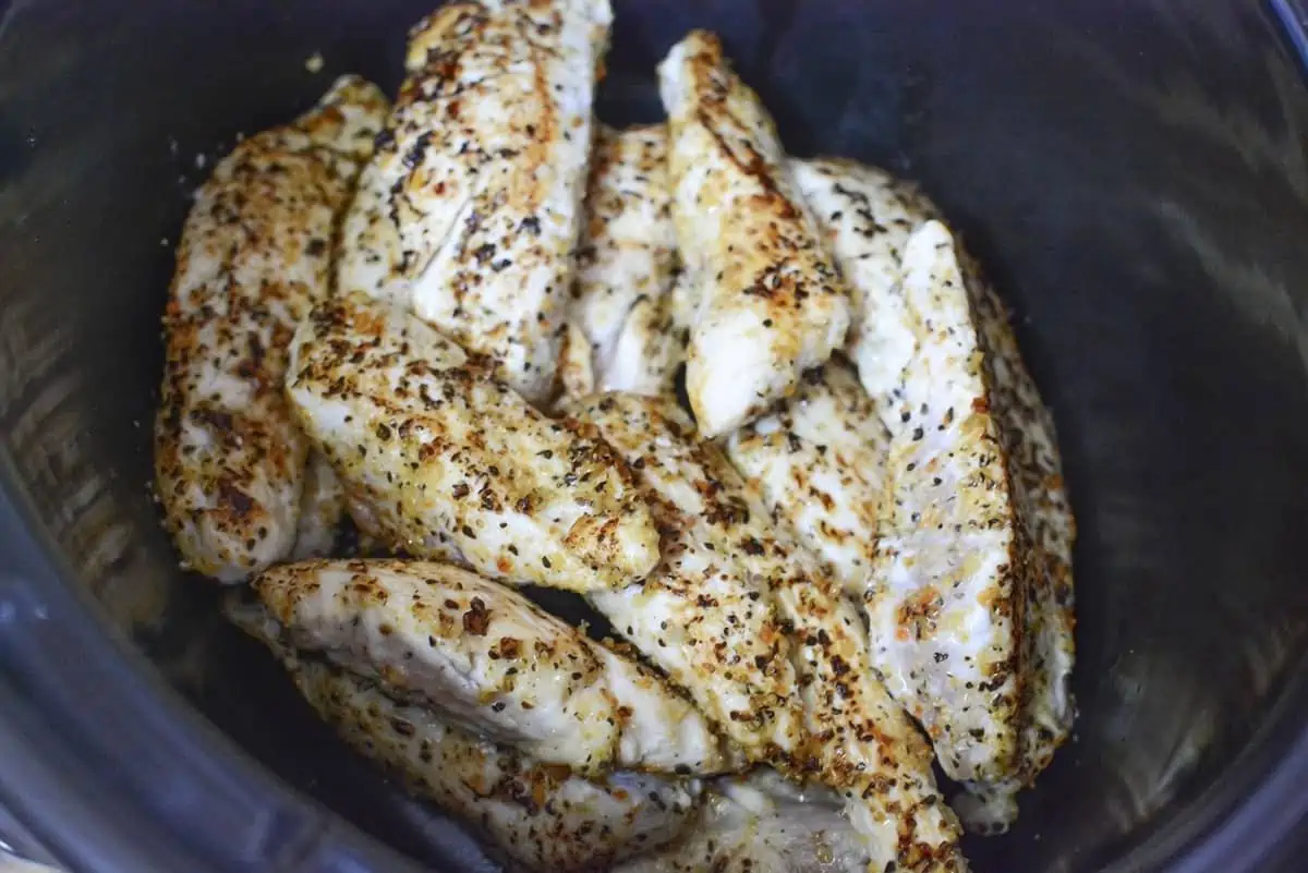 Seared and seasoned chicken in the slow cooker bowl. 